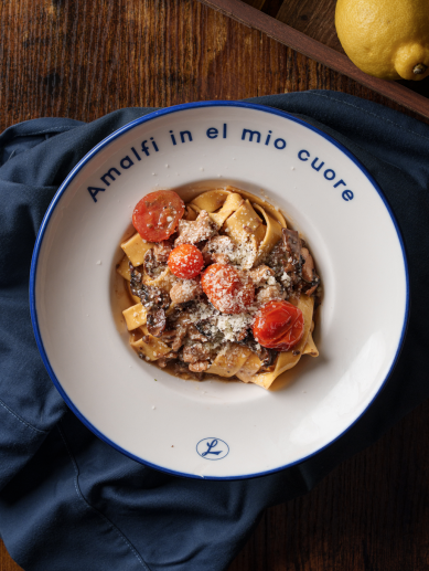 Pappardelle con setas y tomates cherry, en un plato con el lema del local, en Nonna Limone. / Nonna Limone Pappardelle con setas y tomates cherry, en un plato con el lema del local, en Nonna Limone. / Nonna Limone